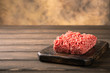 Fresh raw beef minced meat on dark wooden board. Healthy food ingredients concept with copy space.