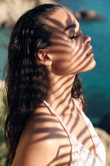 Wall Mural - beautiful girl with dark hair in elegant beach clothes relaxing in tropical island