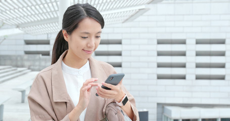 Wall Mural - Woman use of mobile phone and smile to camera