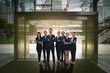 © thithawat - business people professional group of teamwork diverse team standing front of glass