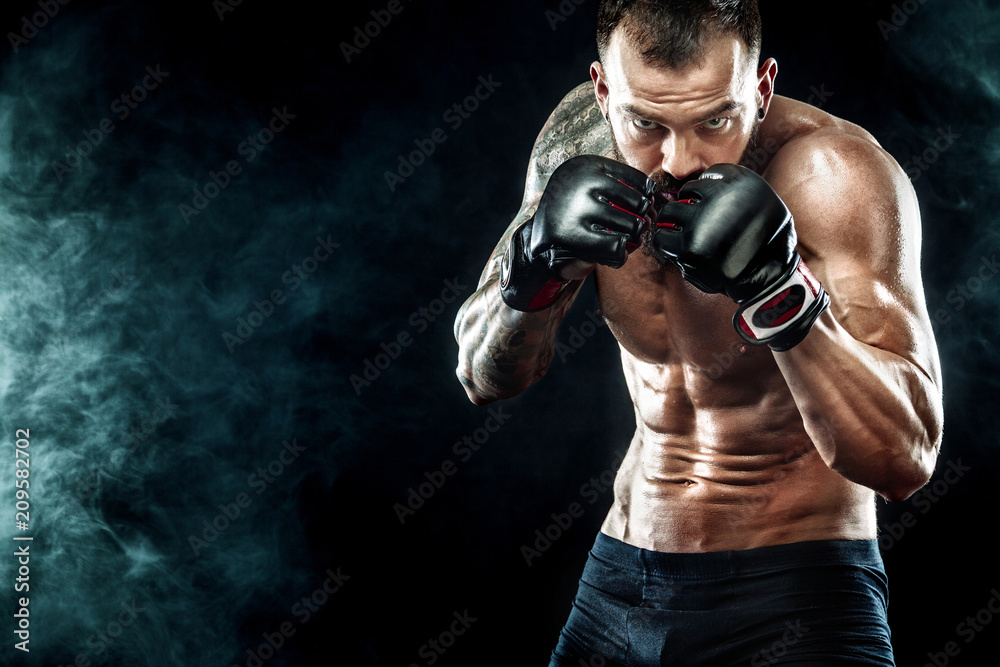 Foto Sportsman boxer fighting on black background