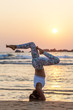 © Maygutyak - Caucasian woman practicing yoga at seashore of tropic ocean