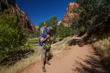 A man with his baby boy are trekking in Zion national park, Utah, USA