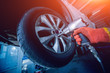© romaset - Professional car mechanic working with pneumatic wrench in auto repair service.
