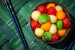 une coquille de noix de coco remplie d'une salade de fruit avec des billes de toutes les couleurs 