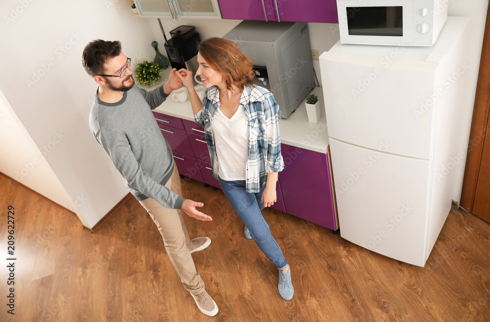 Lovely couple dancing together in kitchen