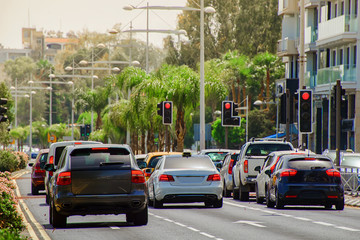 cars stopped at a red traffic light signal in the summer hot midday with a shallow depth of field