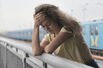 Depressed young woman at railway station