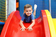 © Africa Studio - Little boy riding on slide in entertainment center