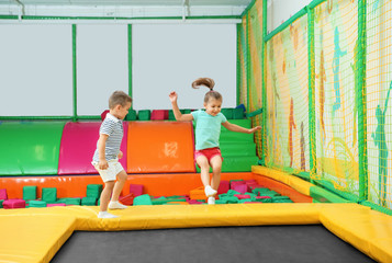 Canvas Print - Cute children playing on trampoline in entertainment center