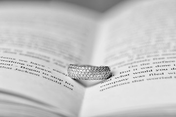 Wall Mural - Engagement ring between pages of book, closeup