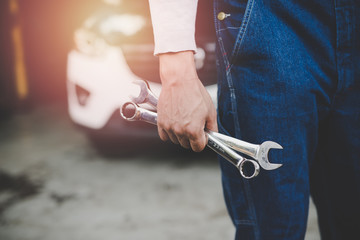 Wall Mural - Hand of car mechanic with wrench at service center repair