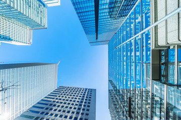 Wall Mural - Asia Business concept for real estate and corporate construction - looking up view of panoramic modern city skyline with blue sky in tokyo, japan