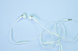 © pookpiik - White Earphones or ear buds small talk on sweet blue colour pastel paper, top view, texture and background. music listening concept.