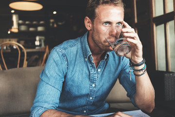 Wall Mural - Portrait of entrepreneur working on his project at street cafe, drinking water