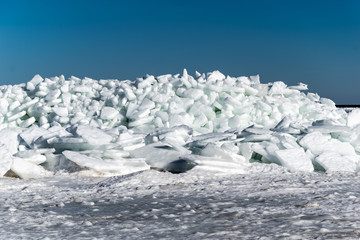 Wall Mural - frozen lake covered with stack of ice floes and blue sky