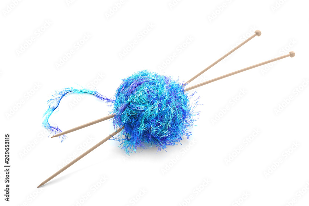 Ball of thread with knitting needles on white background