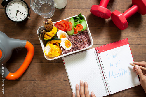 Cuadros en Lienzo Healthy concept with nutrion food in lunch box and fitness equipments with woman