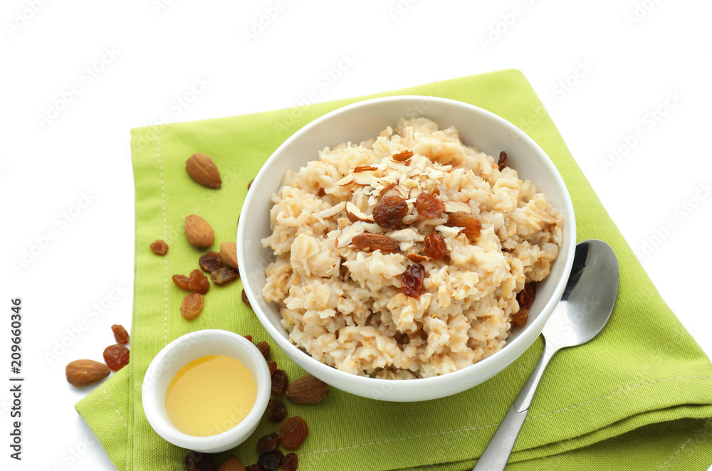Tasty oatmeal with honey, nuts and raisins on white background