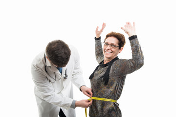 Male doctor measuring happy female senior patient