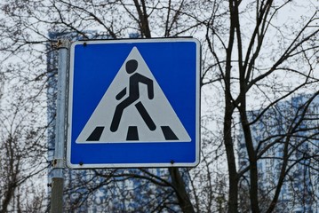 square road sign pedestrian crossing on the background of branches