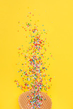 Ice Cream Cone With Colorful Sprinkles On Yellow Background. Closeup, Vibrant Colors.