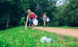 © David Pereiras - Two girls picking up trash while plogging outdoors