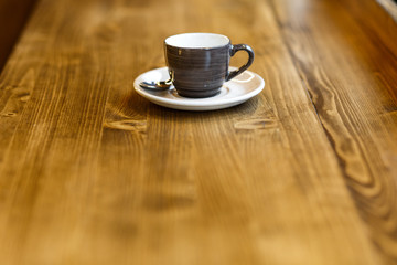 Empty gray cup with a spoon in a cafe on a wooden table