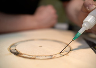 Wall Mural - The guitar master pastes the rosette into a classical guitar.