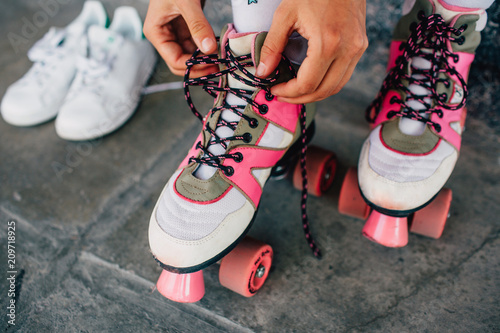 Fotografía A picture of girl lying laces on her pink rollers