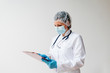 © bnenin - Portrait of a female doctor in protective wear holding chart.