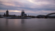 Köln Panorama mit dem Kölner Dom der Groß St. Martinskirche und der Hohenzollernbrücke, bewölkter Himmel und Wellen im Rhein