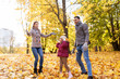© Syda Productions - family, season and people concept - happy mother, father and little daughter playing with autumn leaves at park