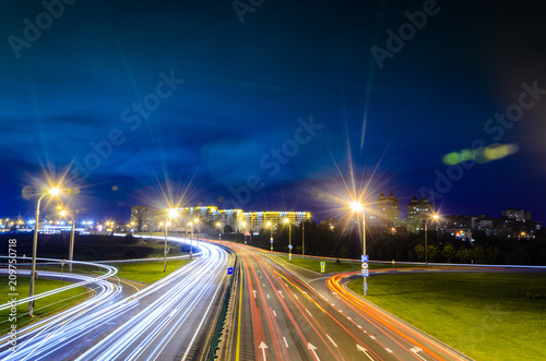 Cuadros en Lienzo Night Traffic with Light Trails on Highway Interchange