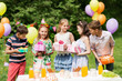 © Syda Productions - holidays, childhood and celebration concept - happy kids with gifts on birthday party at summer garden