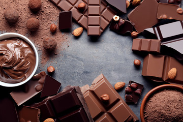 Chocolate pieces with nuts and cocoa balls on grey wooden table