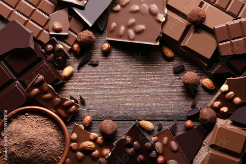 Cuadros en Lienzo Chocolate pieces with cocoa powder in bowl on wooden table
