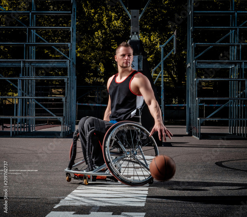 Fotografía Cripple basketball player in a wheelchair plays on open gaming ground