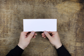 Wall Mural - male hands holding a white blank sheet of paper