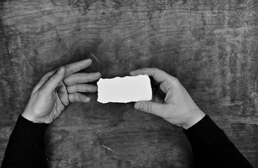 Wall Mural - monochrome photo male hands holding a white blank sheet of paper