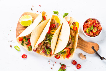 Wall Mural - Mexican pork tacos with vegetables and salsa on white.