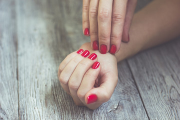 beautiful red manicure of nails on the background of fashionable texture