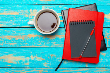 Wall Mural - Cup of coffee with notebook on wooden desk