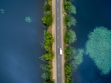 Landscape Of An Asphalt Road. View From Above On The Road Going Along The Blue River. Summer Photography With Bird's Eye View