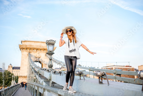 Fotografía Young woman tourist walking on the old Chain bridge during the sunset traveling