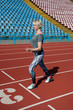 © queen1987 - Sports woman fitness athlete at the start near the stadium, preparing for the sprint. Fitness, the concept of a healthy lifestyle