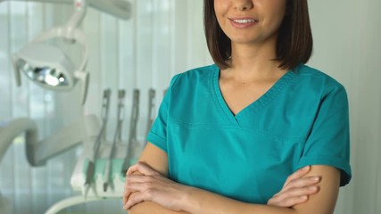 Wall Mural - Professional dentist posing for camera, qualified medical care in modern clinic