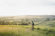 © Photoboyko - Girl riding a bicycle down the hill in beautiful rural landscape at sunset. Young pretty female person with retro bike standing in a meadow on bright sunny afternoon in summer