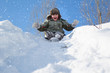 © Светлана Лазаренко - A little boy wearing a hat with a ushanka walks on a snow-covered hill on a winter day.Snowboarding on a sled