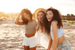 Image of gorgeous caucasian and african american women 20s in stylish clothing laughing and enjoying summertime, while spending weekend at seaside